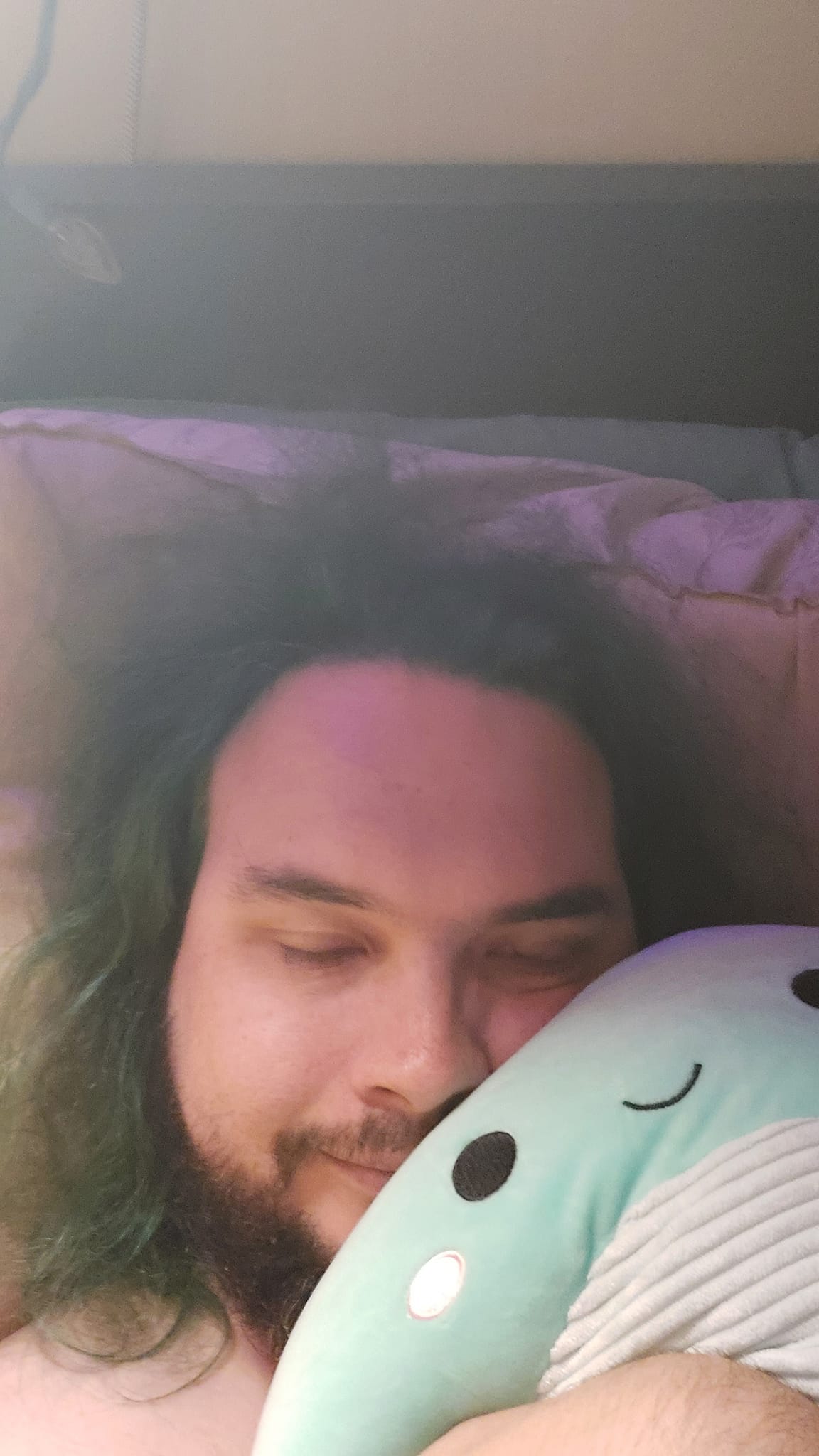 A man with green hair is holding a green Nessie Squishmallow, photo 5